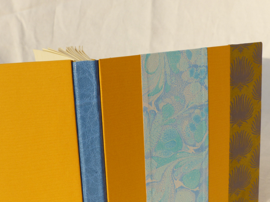 Carnet carré dos en cuir bleu, papiers jaune et orange