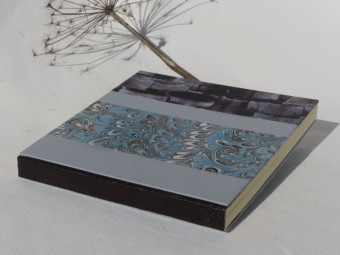 Carnet carré dos en cuir marron, papiers bleu et marron