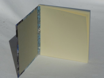 Carnet carré dos en cuir marron, papiers bleu et marron